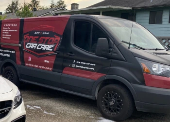 One Stop Car Care service van with a black and red wrap, featuring company branding, contact information, and a list of detailing services on the side, parked in a residential area.