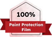 Badge graphic with a pink pentagon and red ribbon across it, displaying the text "100% Paint Protection Film" in bold black and white letters.