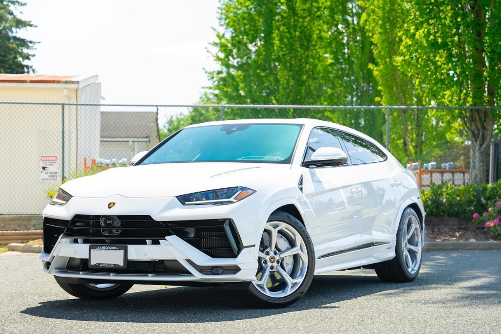A pristine white Lamborghini SUV parked under bright sunlight in Surrey, its flawless paint finish enhanced by paint protection film. The image illustrates how PPF preserves your car's resale value by keeping it in showroom condition.