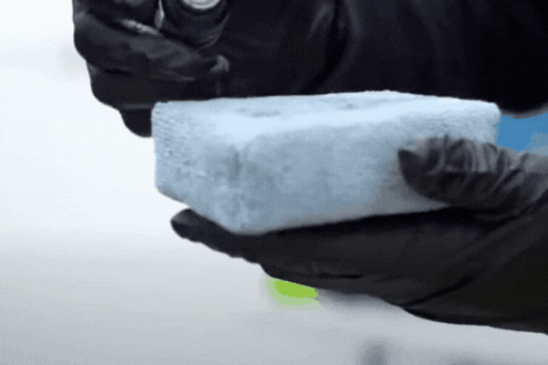 Close-up of gloved hands in Surrey, BC applying a liquid ceramic coating to a microfiber block, demonstrating a key step in the process of Ceramic Coating for Cars by prepping the applicator for paint protection.