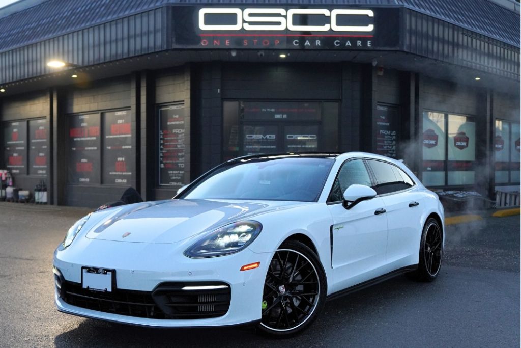White Porsche Panamera parked outside OSCC One Stop Car Care in Surrey with black custom wheels and low profile tires installed. The image highlights vehicle compatibility and professional wheel and tire services in Surrey to ensure safe and precise upgrades.