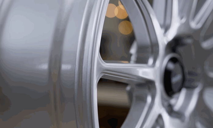 Close up of a silver alloy wheel showing the curved spokes and rim edge. The detail view helps compare rim size style and finish.